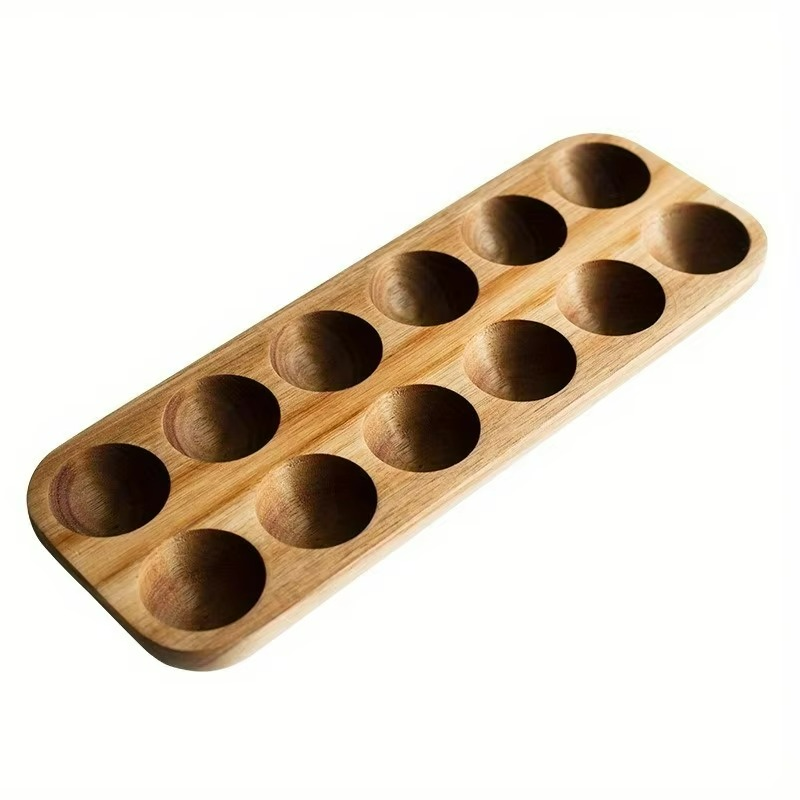 Wooden tray with multiple round depressions on a white background