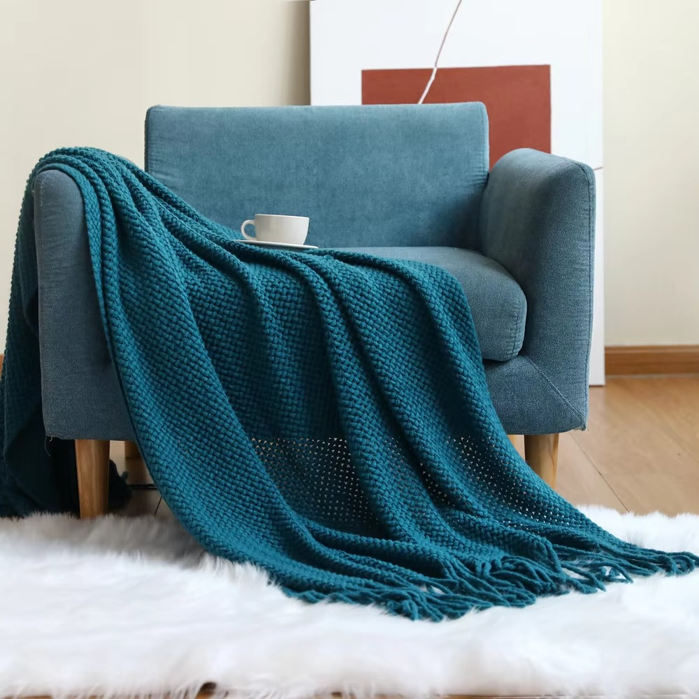 Blue blanket draped over a blue armchair with a white rug underneath