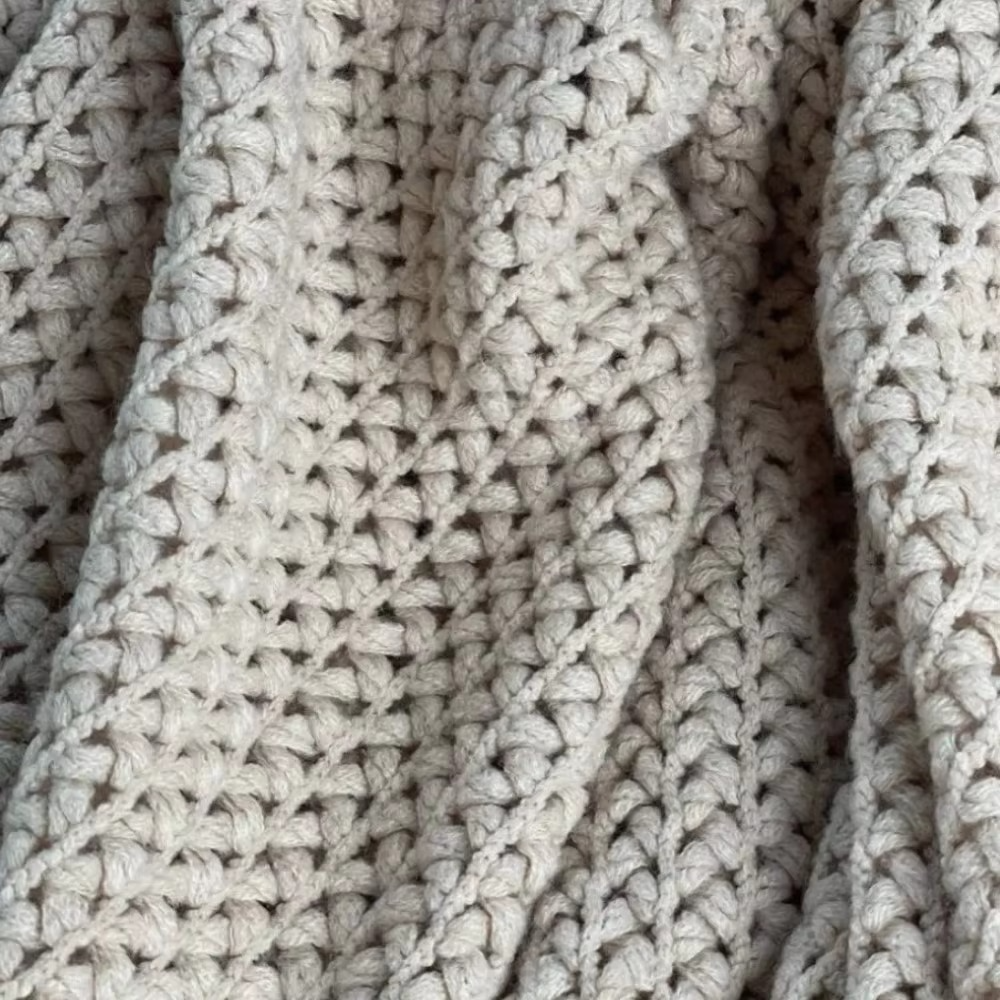 Close-up of a textured beige fabric with a knitted pattern