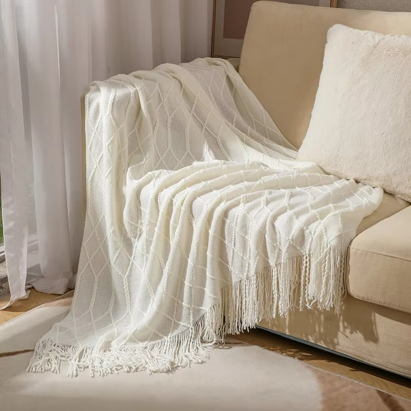 White textured throw blanket draped over a beige sofa in a living room setting.