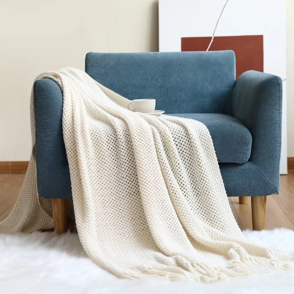 Blue armchair with a white blanket draped over it in a room setting.