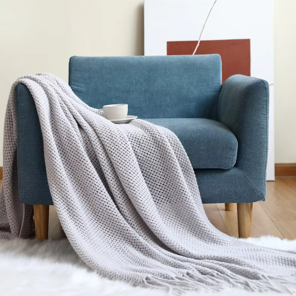 Blue armchair with a gray blanket draped over it in a cozy living room setting.