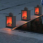 Three decorative lanterns with glowing red interiors on a stone surface.