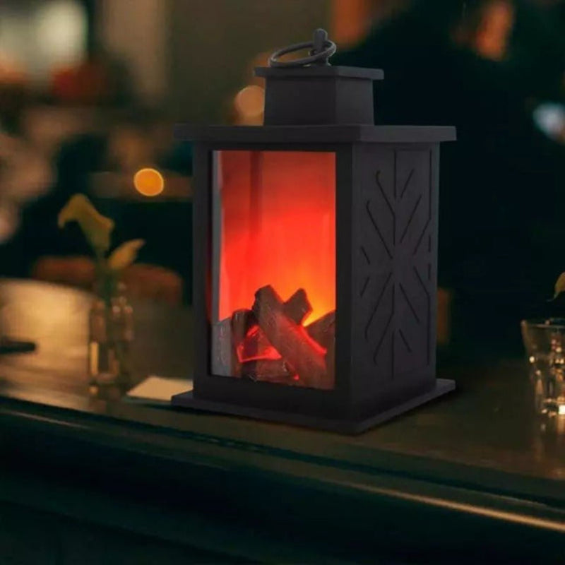 Decorative lantern with glowing interior resembling a fireplace on a table.