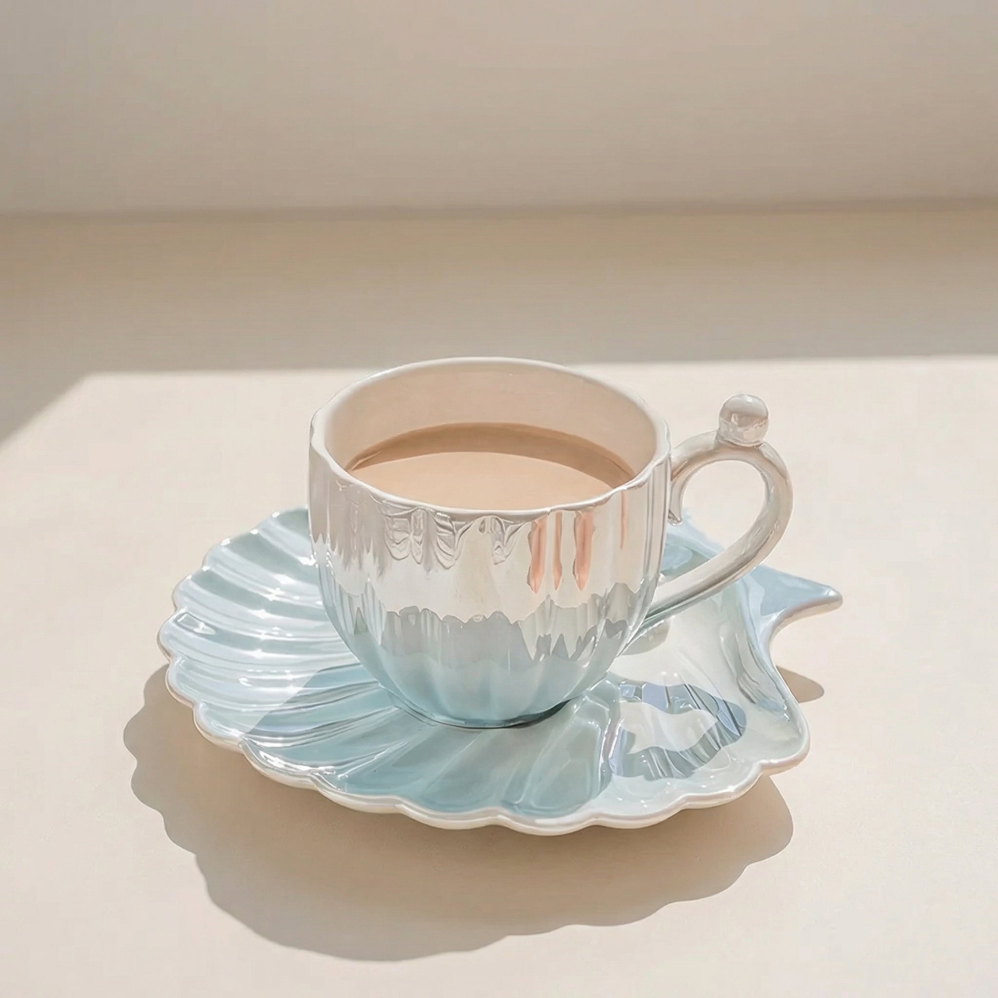 Teacup with light blue design on a matching saucer on a white surface