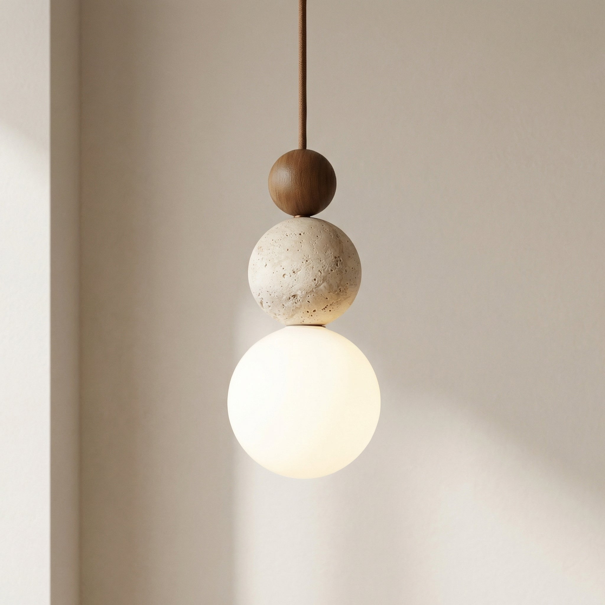 Pendant light with three spherical elements on a neutral background