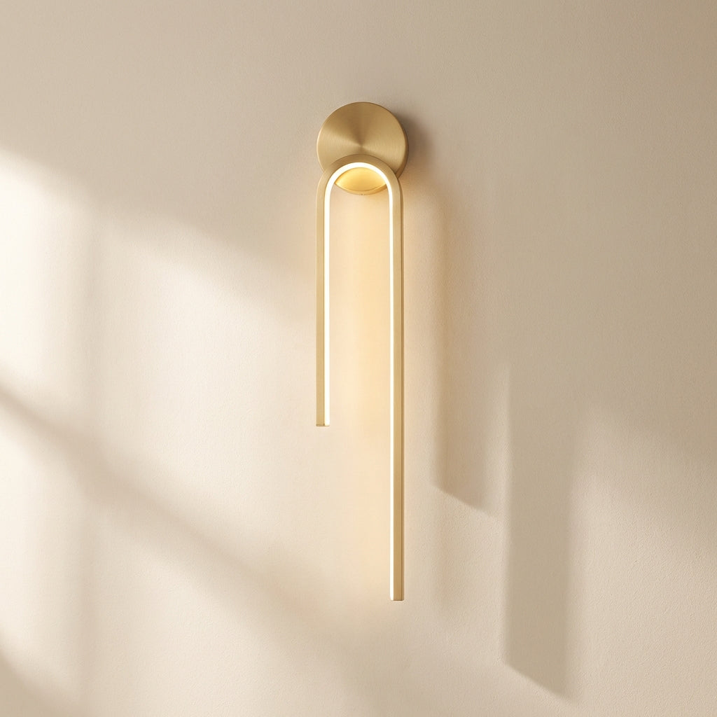 Gold wall sconce on a beige wall