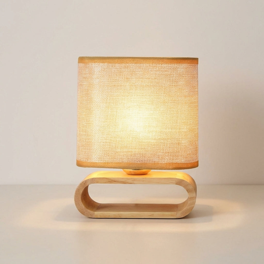 Wooden table lamp with a beige lampshade on a light background