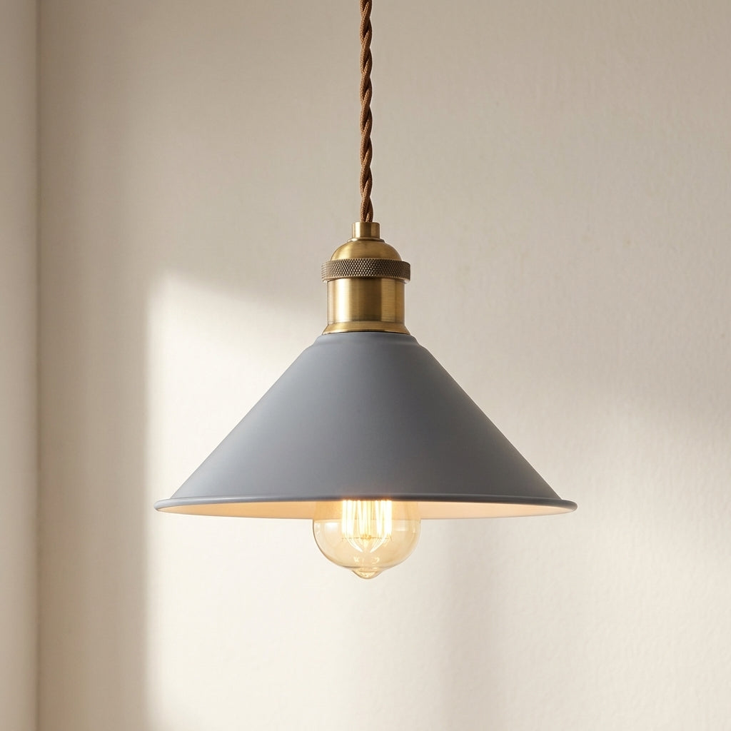 Pendant light with gray shade and brass fixture on a neutral background