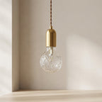 Decorative light bulb with gold fixture against a neutral background
