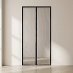 Black-framed mesh screen door in a minimalistic room with light-colored walls and floor.