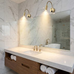 Modern bathroom with marble walls, a vanity, and a large mirror.