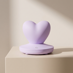 Heart-shaped purple device on a beige surface with a neutral background
