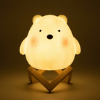 Cute dog-shaped night light on a wooden stand with a warm glow against a dark background