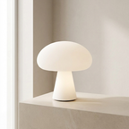 White mushroom-shaped table lamp on a shelf with a neutral background