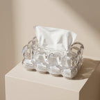 Clear glass egg carton with a white napkin on a beige surface