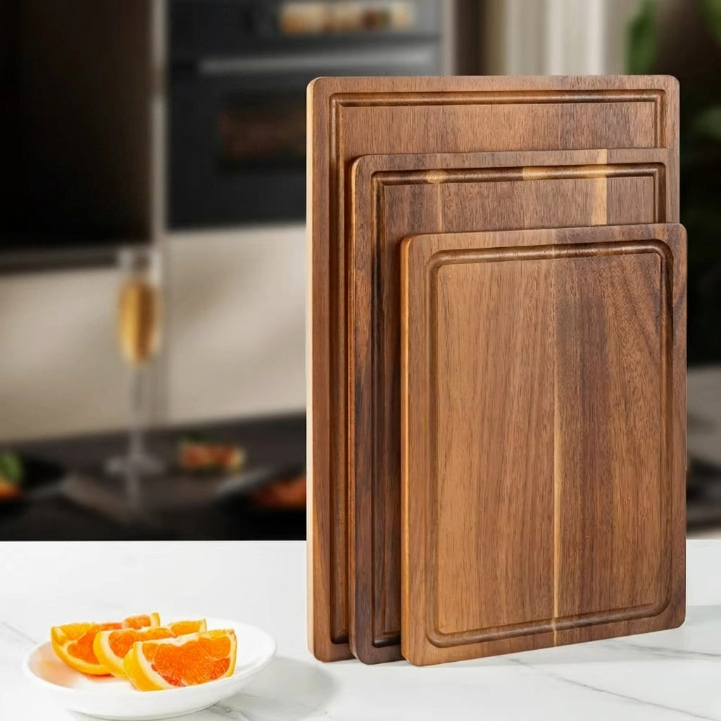 Set of wooden cutting boards on a kitchen counter with a plate of oranges.