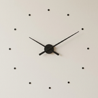 Black wall clock with minimalistic design on a light gray background