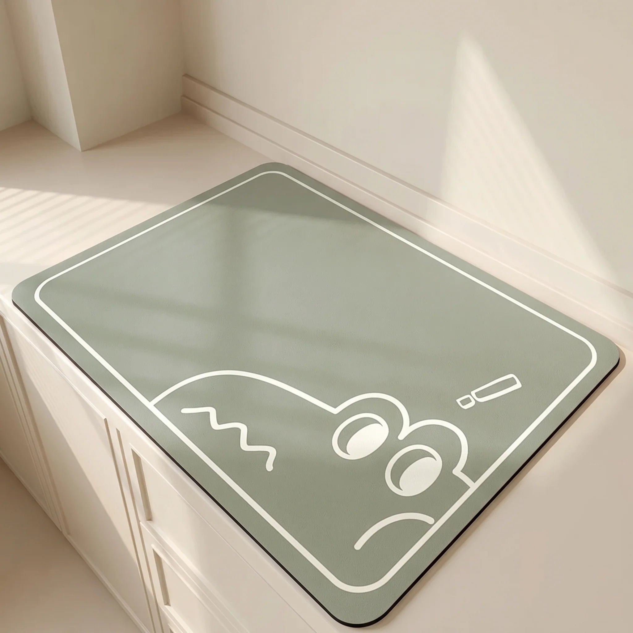 Green mat with a white cartoon design on a light wooden floor.