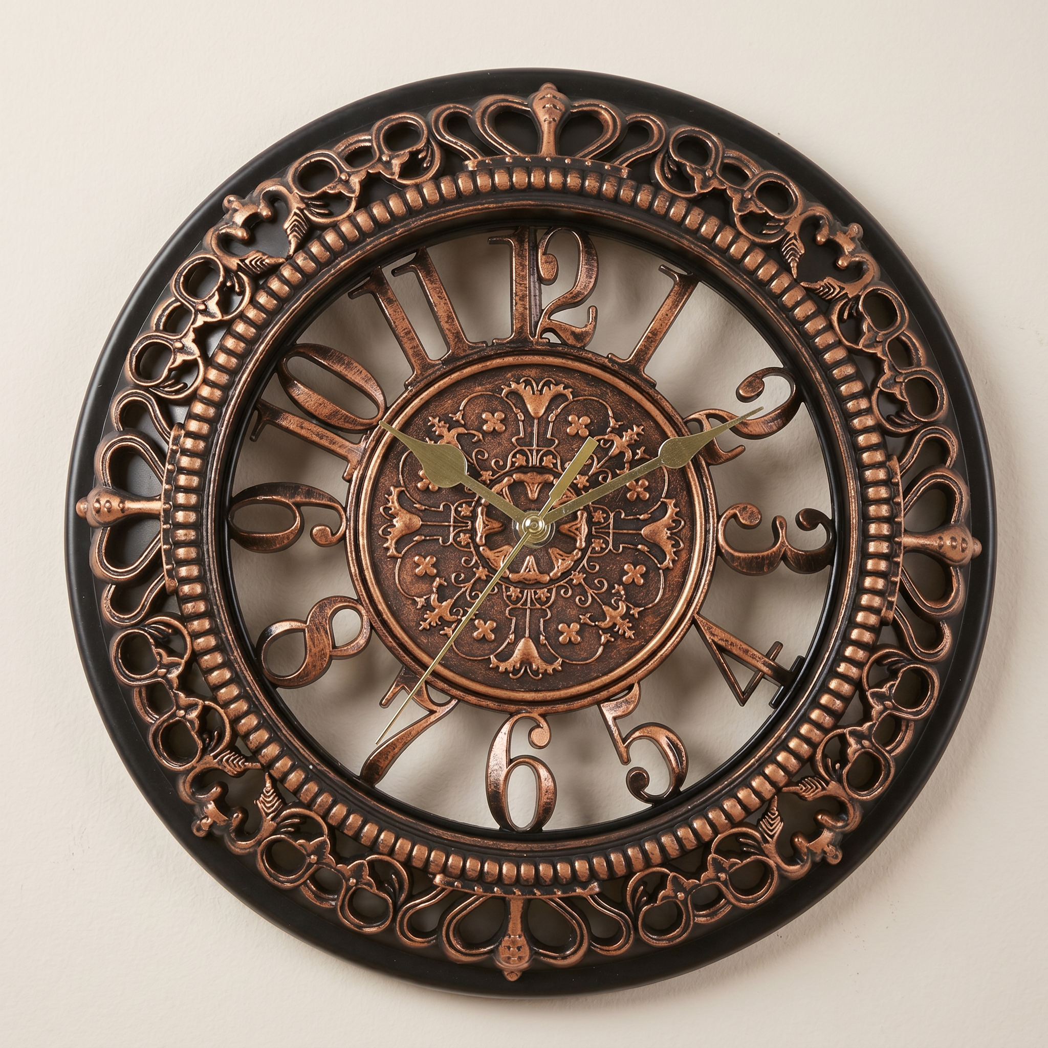 Decorative wall clock with intricate designs on a beige background