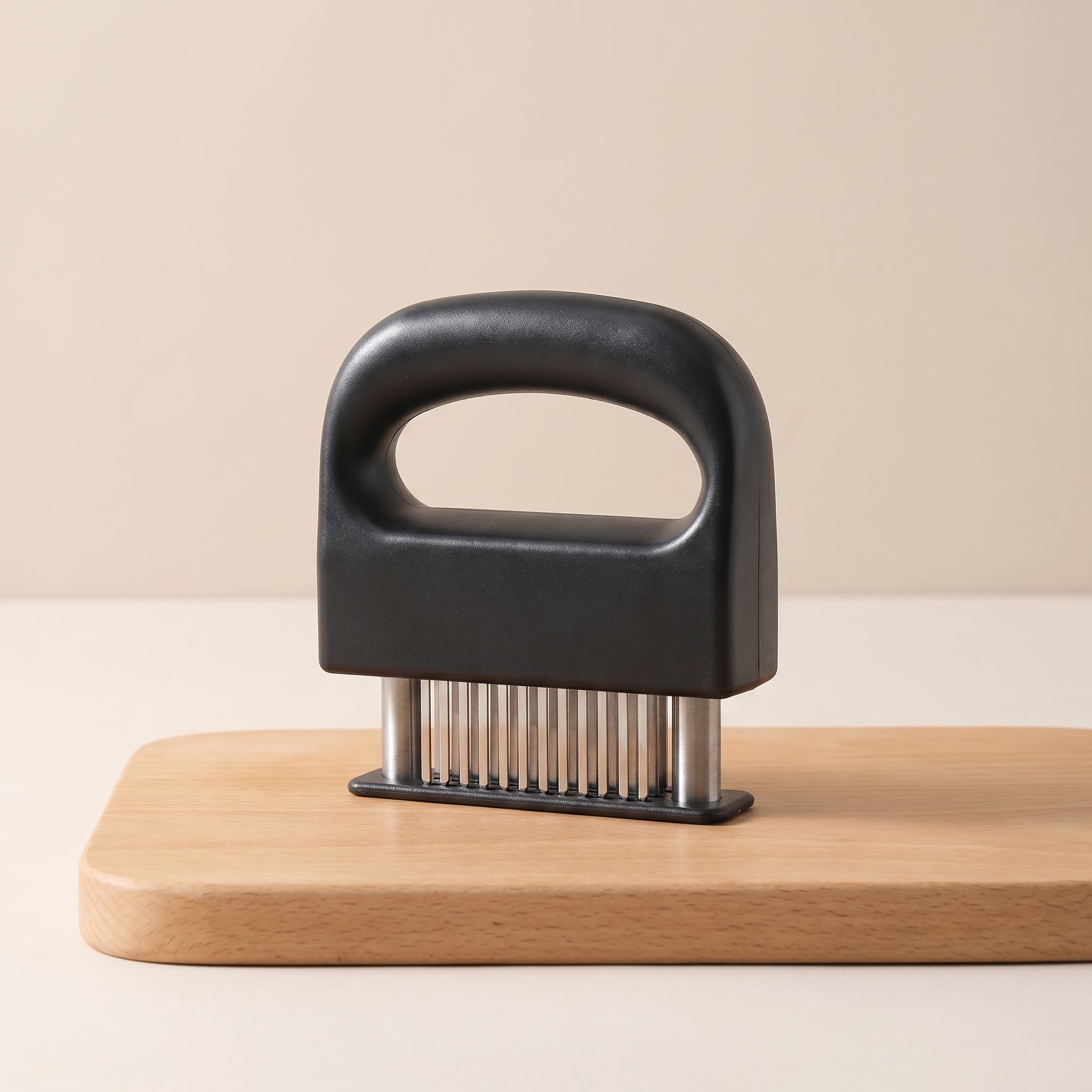 Black meat tenderizer on a wooden cutting board with a beige background