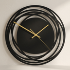 Modern wall clock with black and gold design on a neutral background