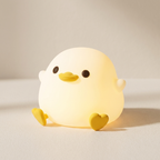 Yellow duck-shaped night light on a beige background
