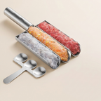 Metallic ice cream mold with three compartments filled with different colored ice cream, accompanied by three metal spoons on a beige background.