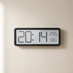 Digital clock with time, temperature, and humidity display on a beige wall.