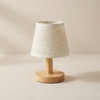 Small table lamp with a woven shade and wooden base on a beige background