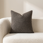 Textured brown pillow on a beige sofa against a neutral wall