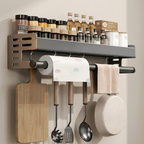 Wall-mounted kitchen organizer with cutting board, utensils, paper towels, and spices.