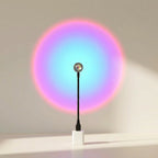 Colorful circular light projection on a plain wall with a black stand.
