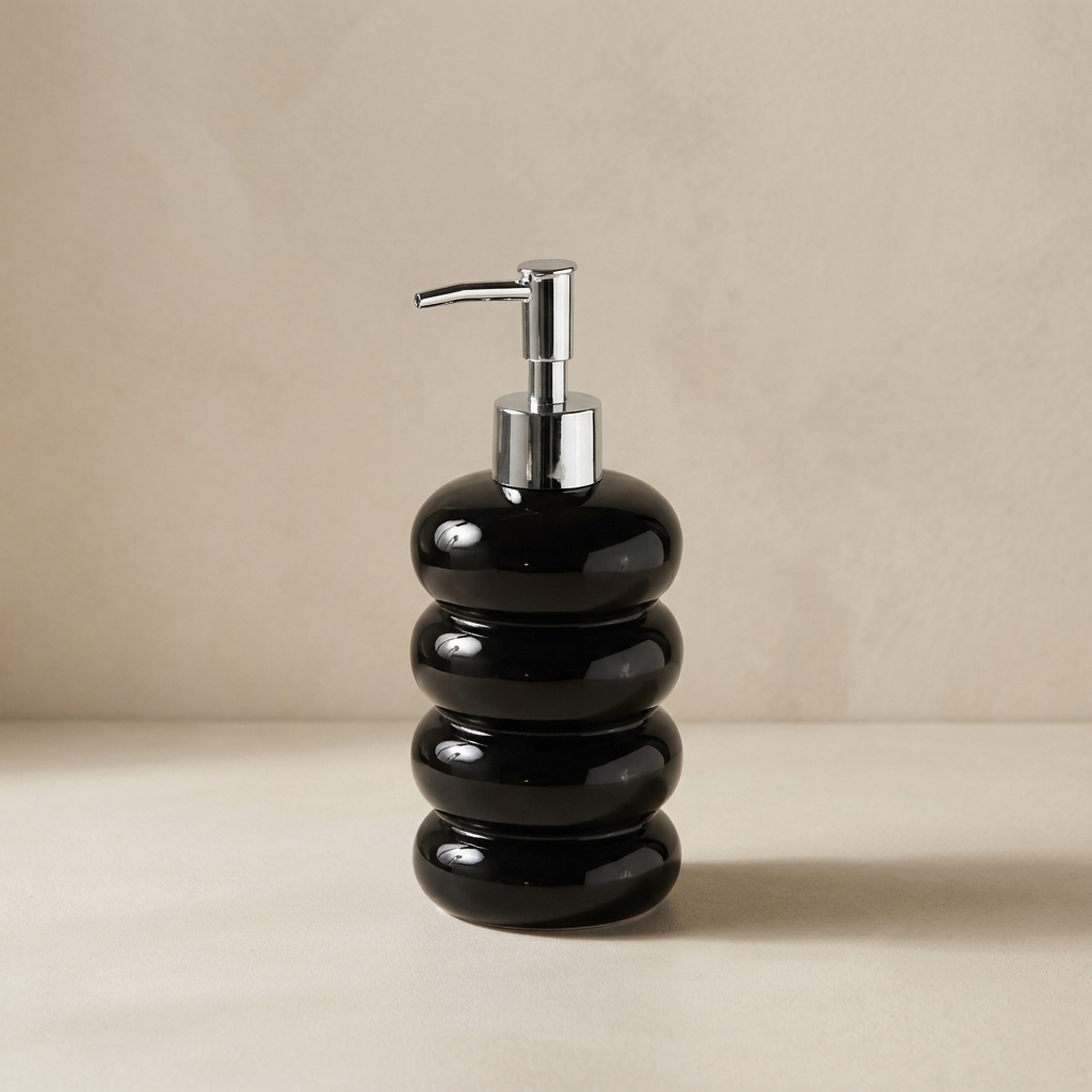 Black ceramic soap dispenser with silver pump on a beige background