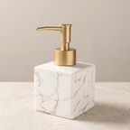 Marble-patterned soap dispenser with gold pump on a neutral background