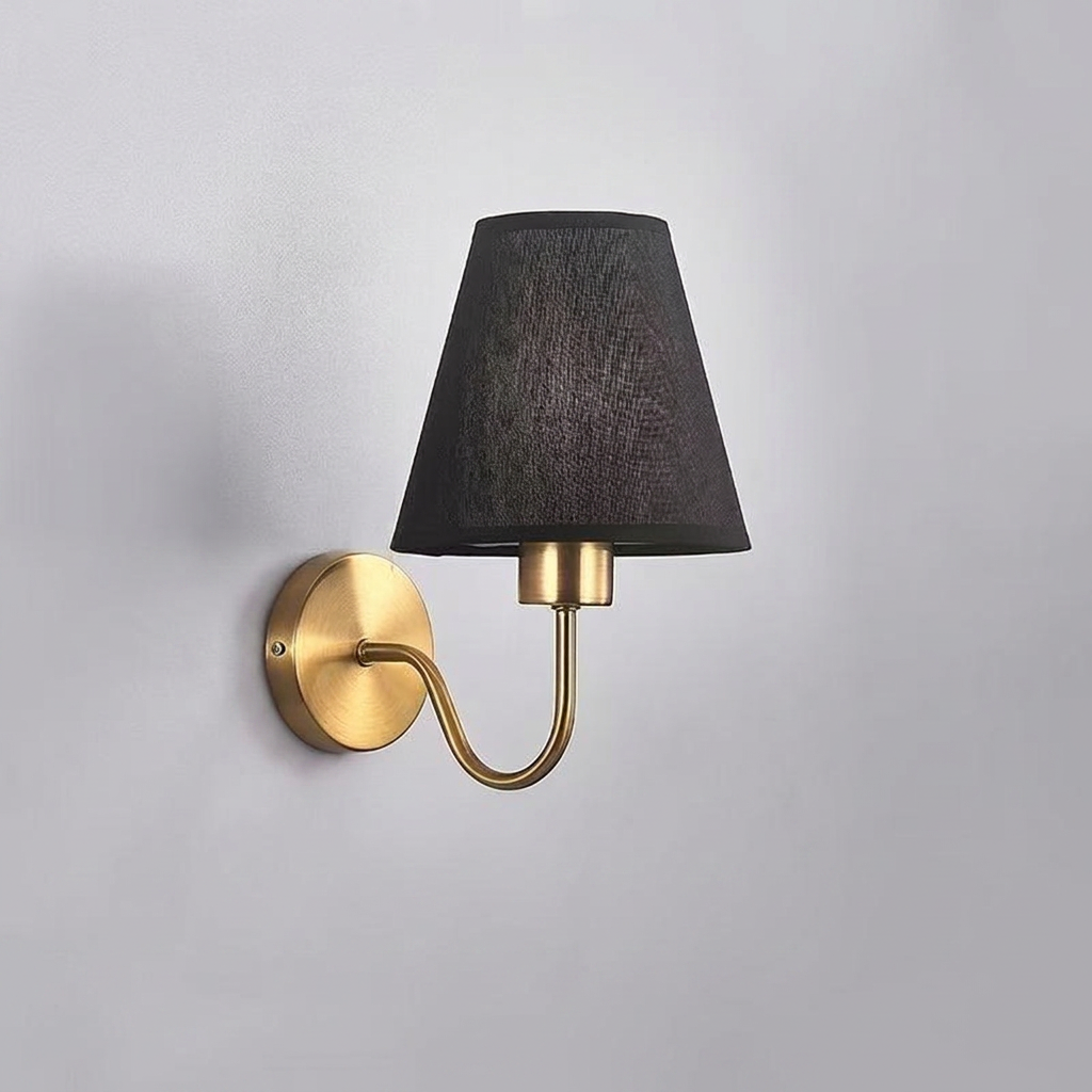 Wall-mounted lamp with black shade and gold arm on a gray background
