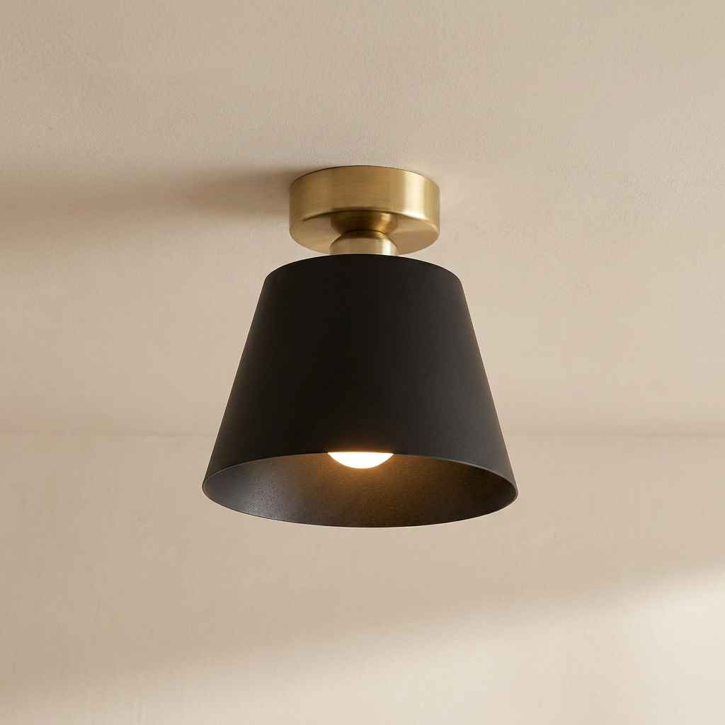 Ceiling light fixture with black shade and gold fixture on a beige ceiling