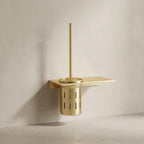 Gold wall-mounted toilet brush holder on a beige wall