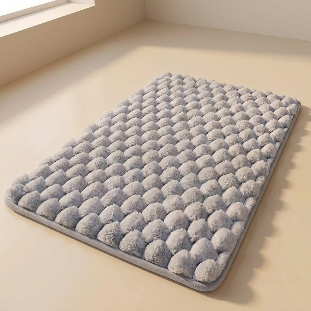Gray textured bath mat on a beige floor