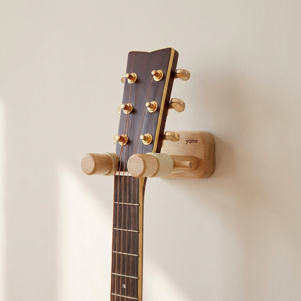 Guitar headstock attached to a wooden guitar stand on a light beige wall.