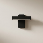 Modern black wall-mounted shelf on a beige wall