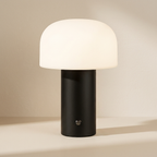 Table lamp with white shade and black base on a beige background