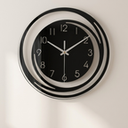Black wall clock with white hands on a light gray background