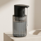 Clear soap dispenser with black pump on a light background