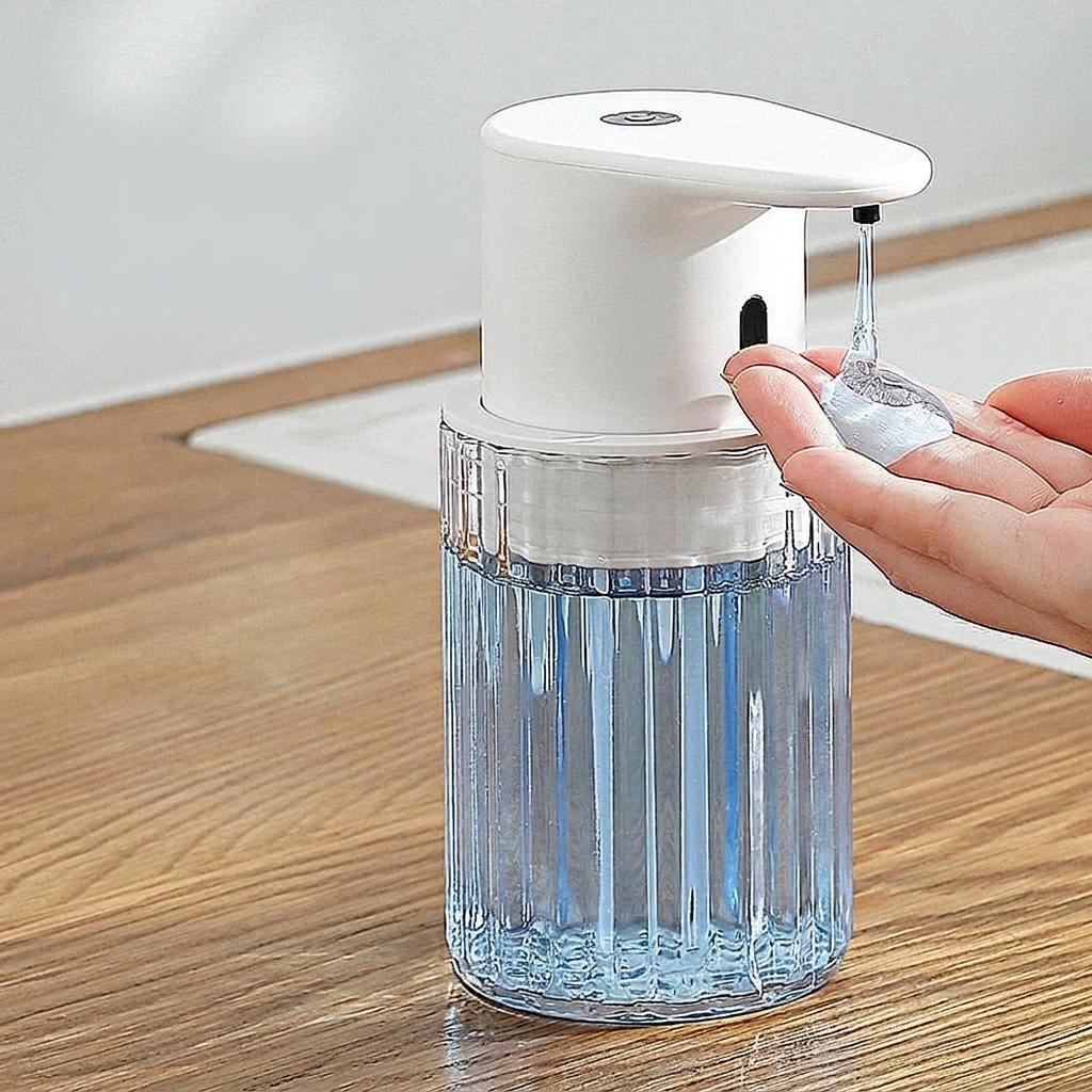 Hand soap dispenser on a wooden surface with a hand scooping soap.