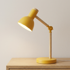 Yellow desk lamp on a wooden surface with a plain background