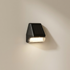 Black outdoor wall light fixture on a beige wall