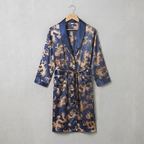 Blue satin robe with gold dragon pattern on a hanger against a gray background