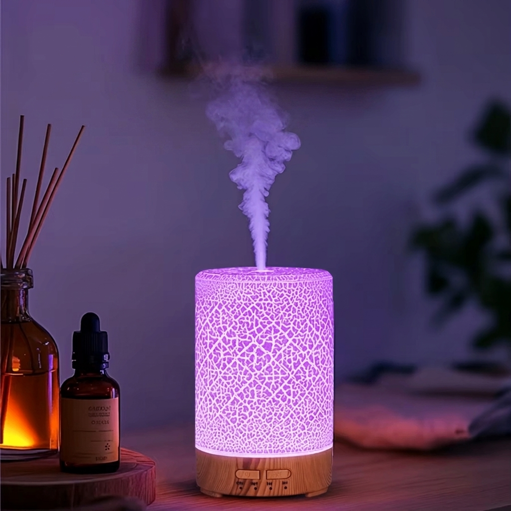 Decorative diffuser emitting mist with bottles and reeds on a wooden surface.