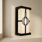 Modern wall-mounted light fixture with a black frame and white glass shade on a neutral wall.